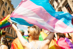Person at a Pride parade waving a Trans flag