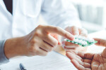 Pharmacist handing medication to patient
