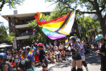 Derby girl waving a Progress Pride flag at the 2022 Rochester Pride Parade